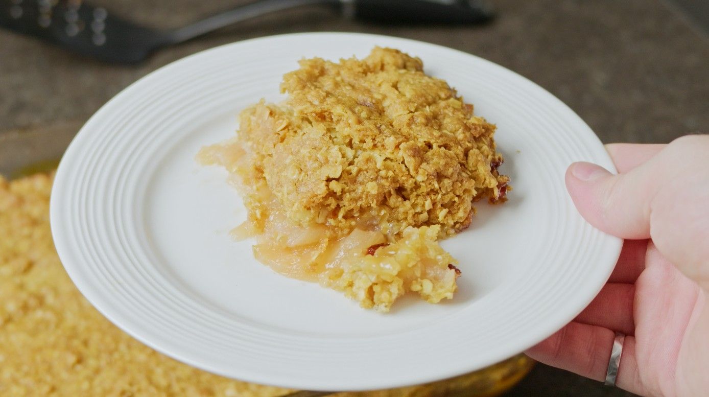 A serving of apple crisp on a white plate